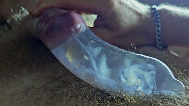 男人戴着避孕套，用热水勐烈射精